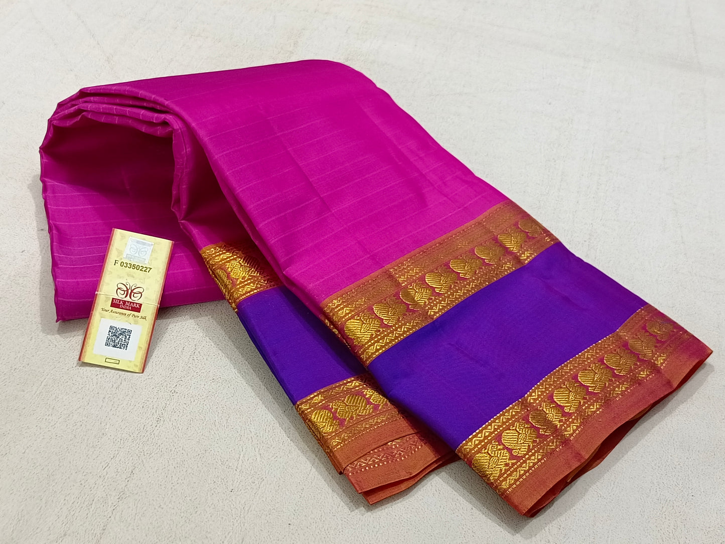 Traditional pink kanchipuram silk saree with blue border and turmeric pallu